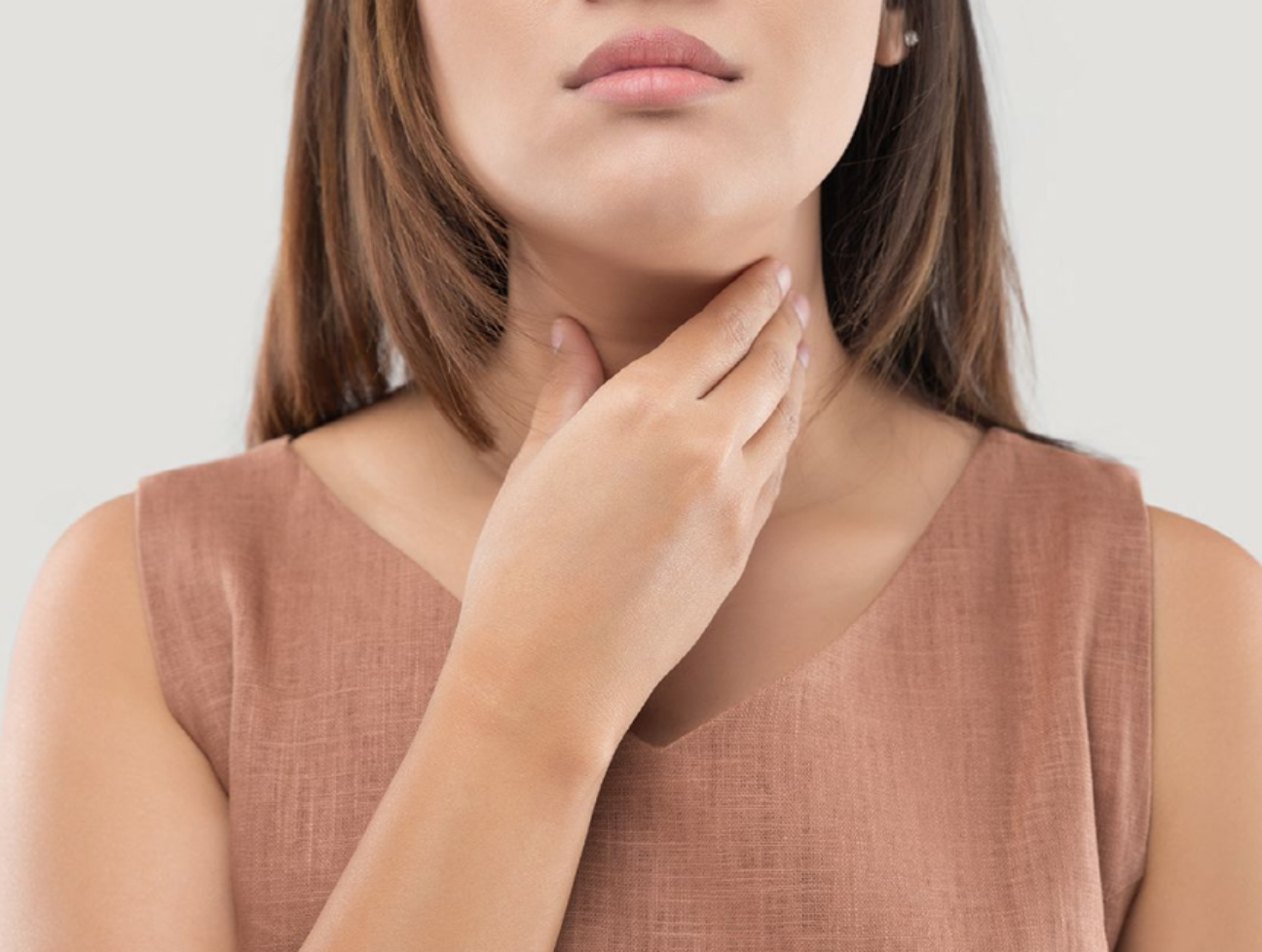 목을 손으로 감싼 여성