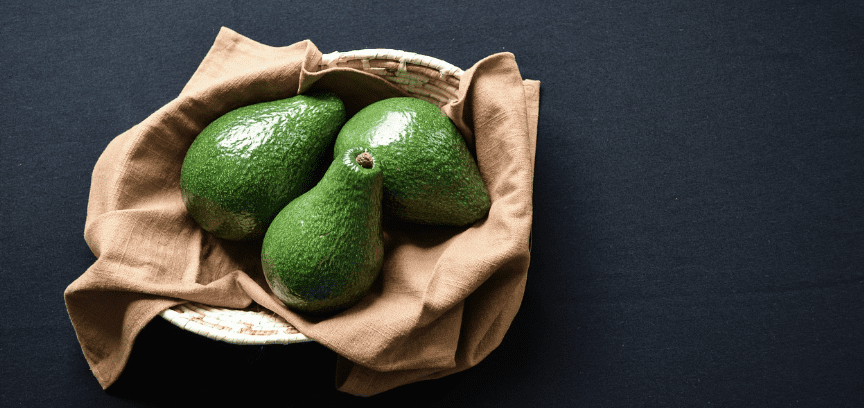그릇에 아보카도 열매 세개가 담겨 있다