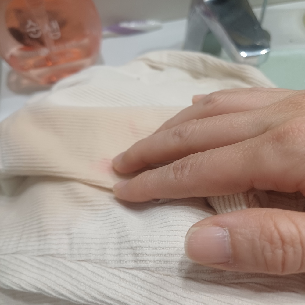 과일 얼룩 제거를 위해 식초가 옷감 섬유에 잘 스며들도록 손가락으로 가볍게 톡톡 두드리는 과정