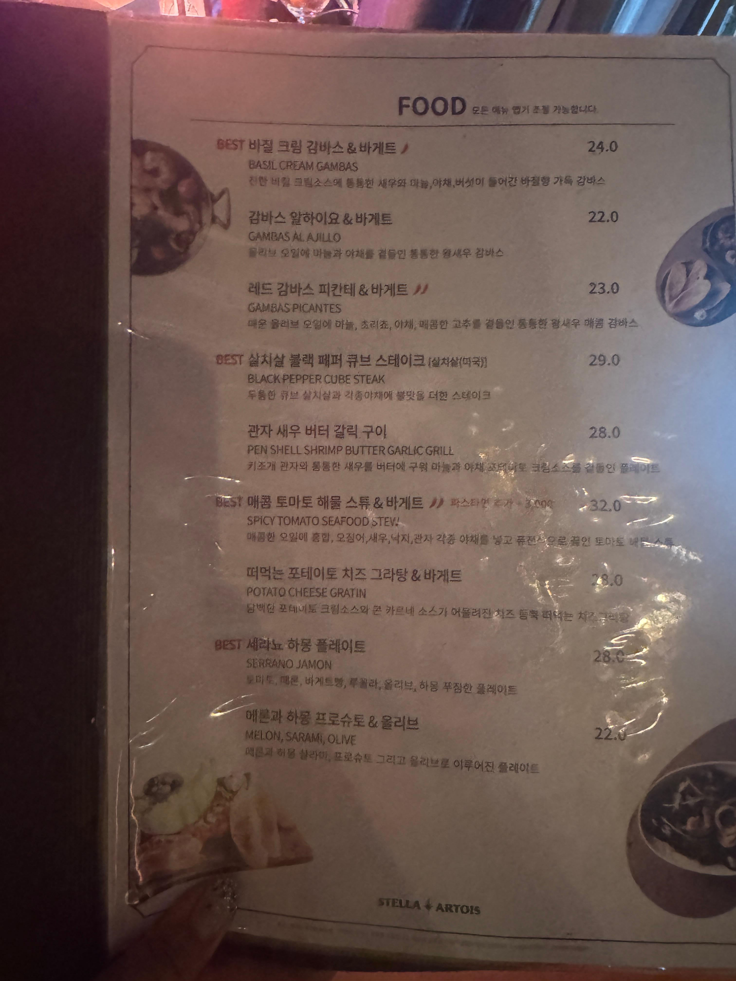 논현 비노비스 와인바의 안주 메뉴판. 세라뇨 하몽 플레이트&amp;#44; 바질 감바스&amp;#44; 큐브 스테이크 등 다양한 메뉴 중 BEST 표시가 된 항목들이 있다.