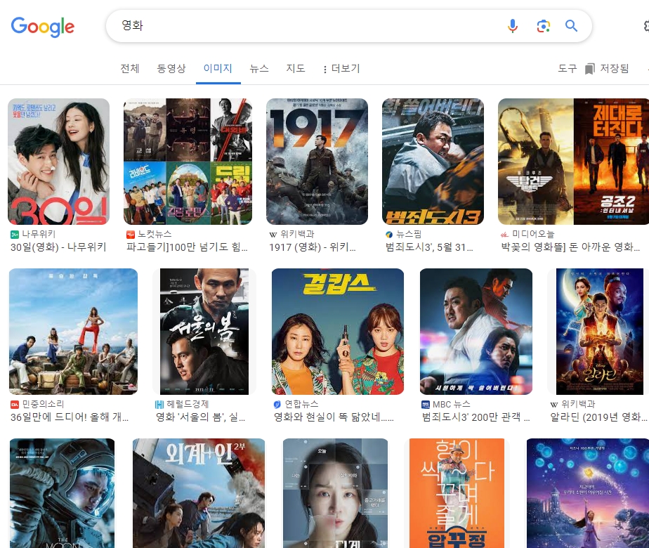 영화관 객석에 앉아 스크린을 바라보며 영화를 관람하는 사람들의 뒷모습