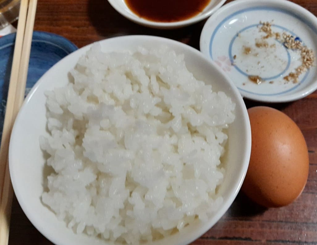 흰 쌀밥과 계란이 테이블 위에 올려져 있는 사진