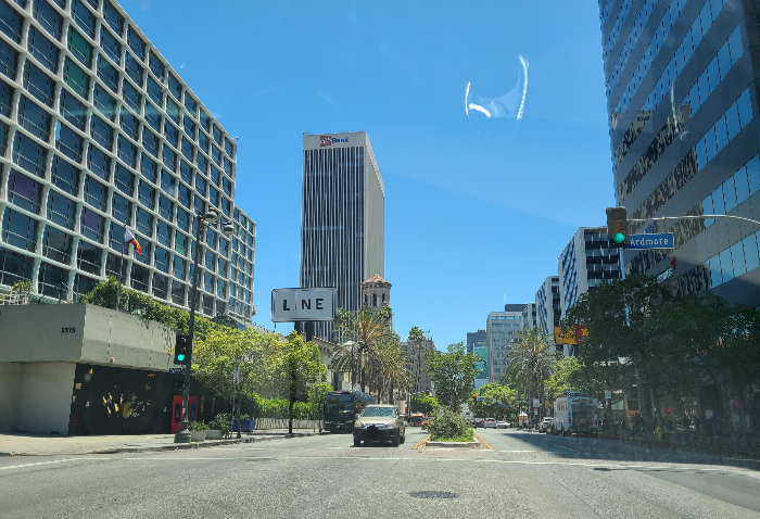 라인호텔 앞 도로. 왼쪽으로 라인호텔이 있고 그 앞에는 LINE이라는 팻말이 크게 세워져 있다. 도로 양쪽으로는 야자수들이 늘어져 있다.