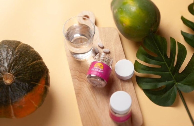 힐미-브로멜라인-통-2개가-늙은-호박과-물컵-사이에-있습니다.