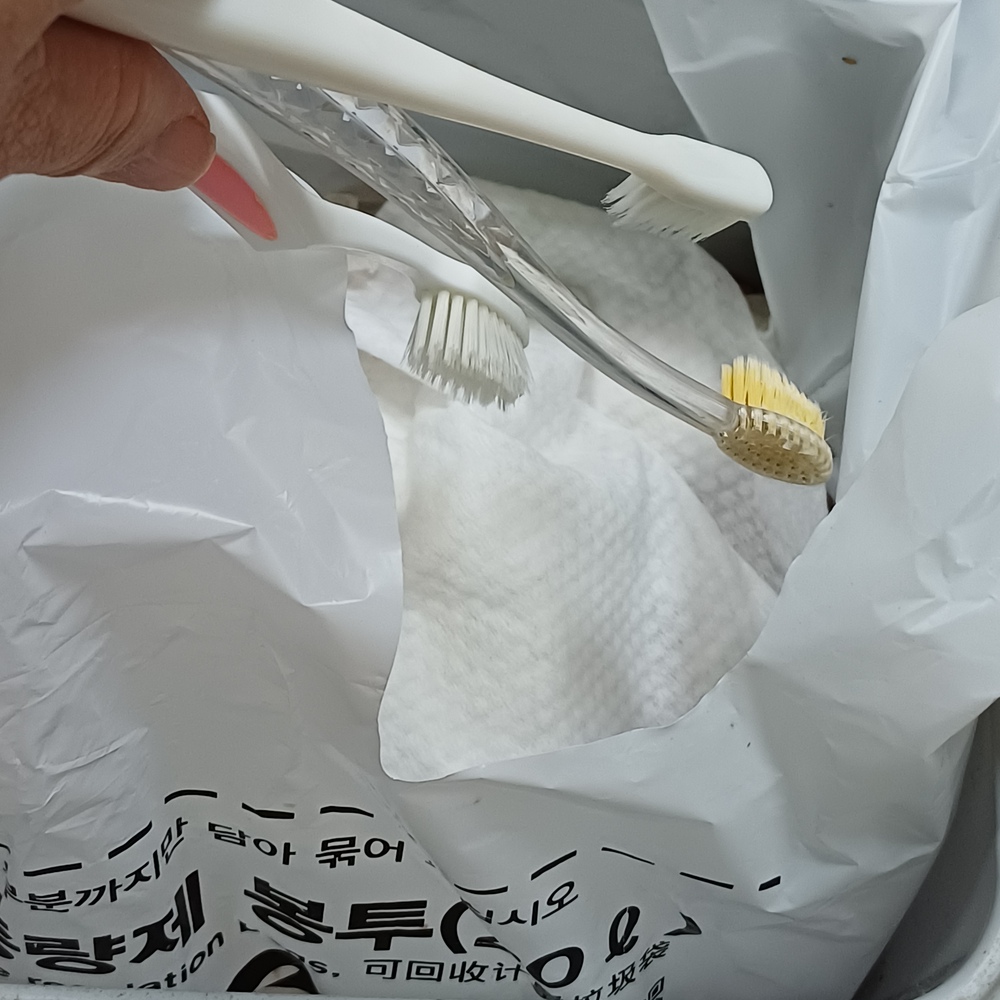 사용한 칫솔을 일반 쓰레기로 정리하는 모습