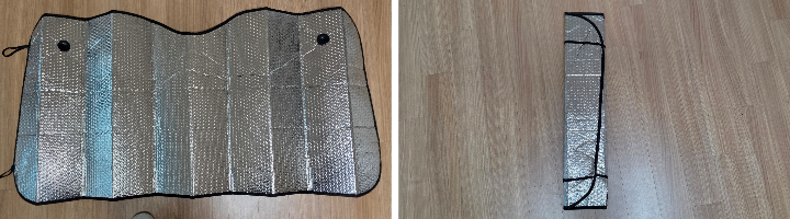 여름철 햇빛을 차단하기 위해 차량 앞유리에 설치된 은색 반사 햇빛가리개. 내부 대시보드와 핸들을 강한 햇볕으로부터 보호하는 장면.