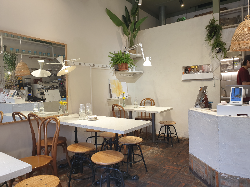 화이트 벽체와 적벽 바닥 그리고 화이트 테이블로 인테리어 된 내부