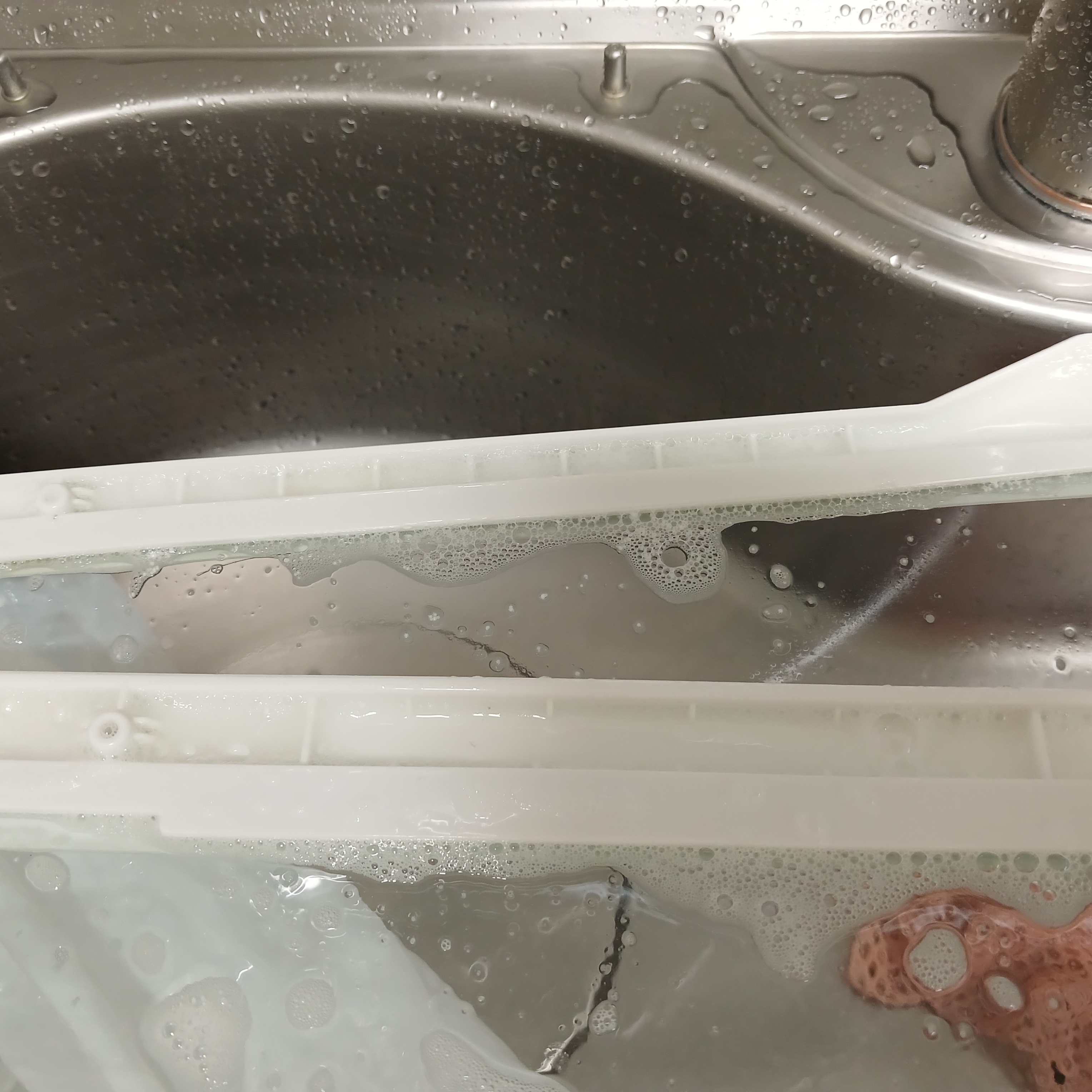 비닐 밀폐 후 꺼낸, 거품과 찌든 때가 충분히 불어난 냉장고 선반 프레임 상세 모습