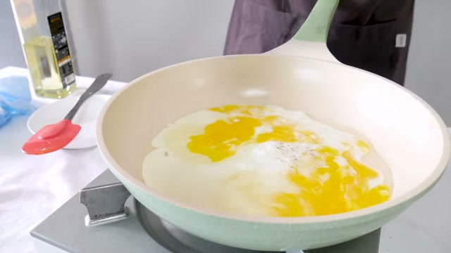 팬에 계란을 풀어 익히는 장면