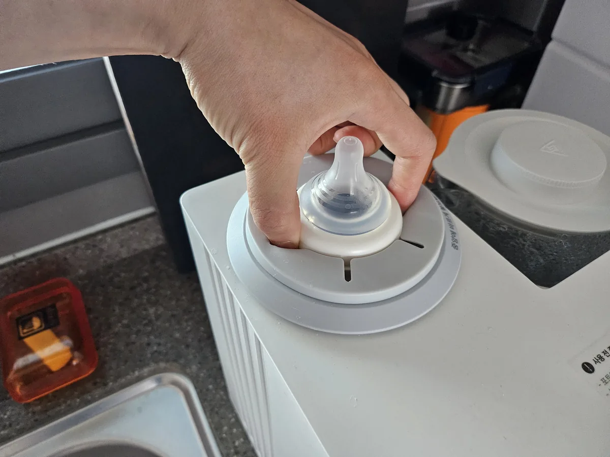 매립된 모윰 젖병을 쉐이커 깊숙이 손을 넣어 빼내는 모습