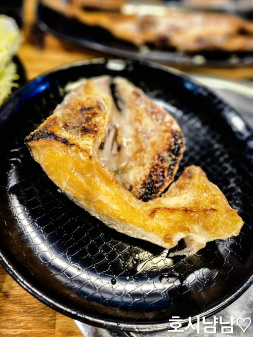 하남 920숙성회 머리구이 - 고소하게 구워진 생선 머리구이와 고명으로 장식된 한 접시