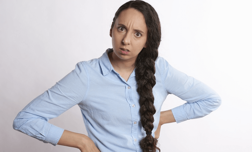 항문이 가려운 이유를 인정하고 있는 여자가 서 있다