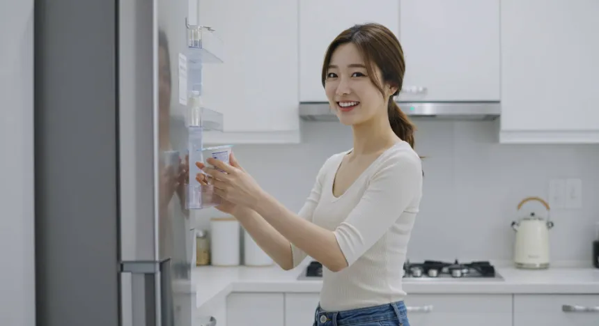 냉장고에서 그릭 요거트를 꺼내는 여자 이미지