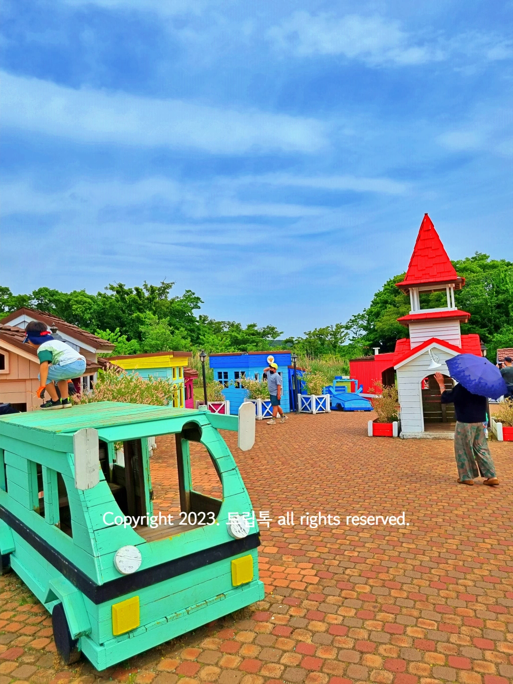 나무로 만든 민트색 자동차롸 빨간 탑이 있는 놀이터