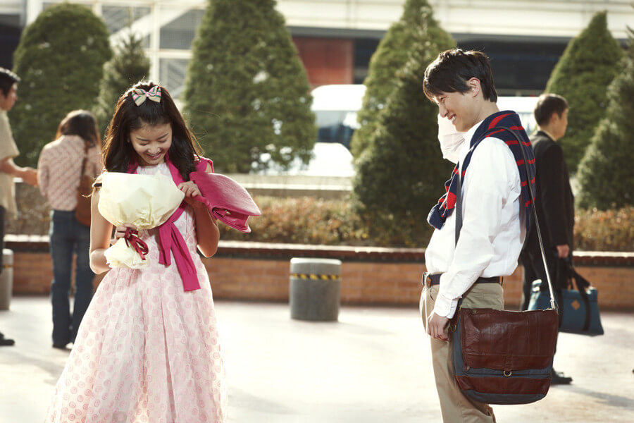 두 남녀가 부끄러운 듯 서로를 바라보지 못하고 웃고 있는 모습