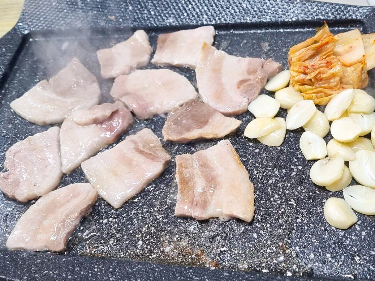 냉동삼겹살을 철판 위에 올려 굽는 사진