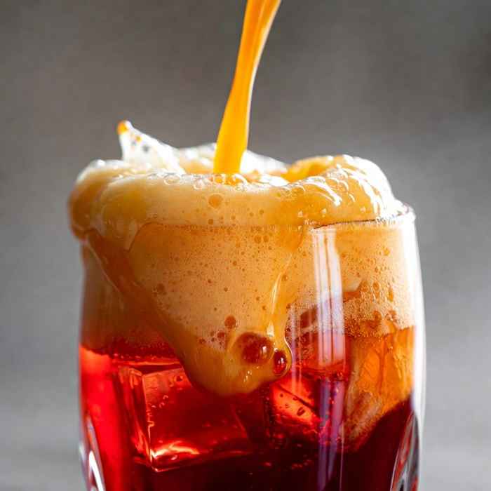 캄파리 위에 거품을 낸 오렌지 주스를 부어 층을 만드는 가리발디 제조 과정