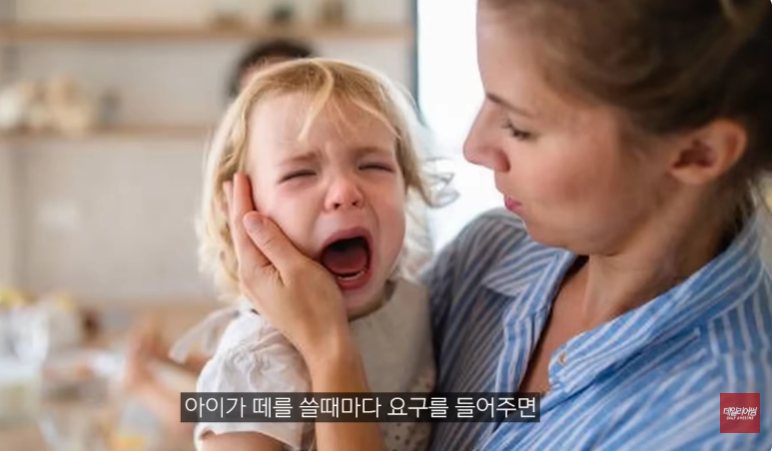 아이가 떼를 쓰며 울 때 부모가 요구를 들어주는 상황을 보여주는 육아 훈육 이미지