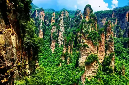 청명한-하늘-파란-구름과-함께-하늘로-솟아오르는-듯한-압도적인-봉우리들로-가득한-원가계