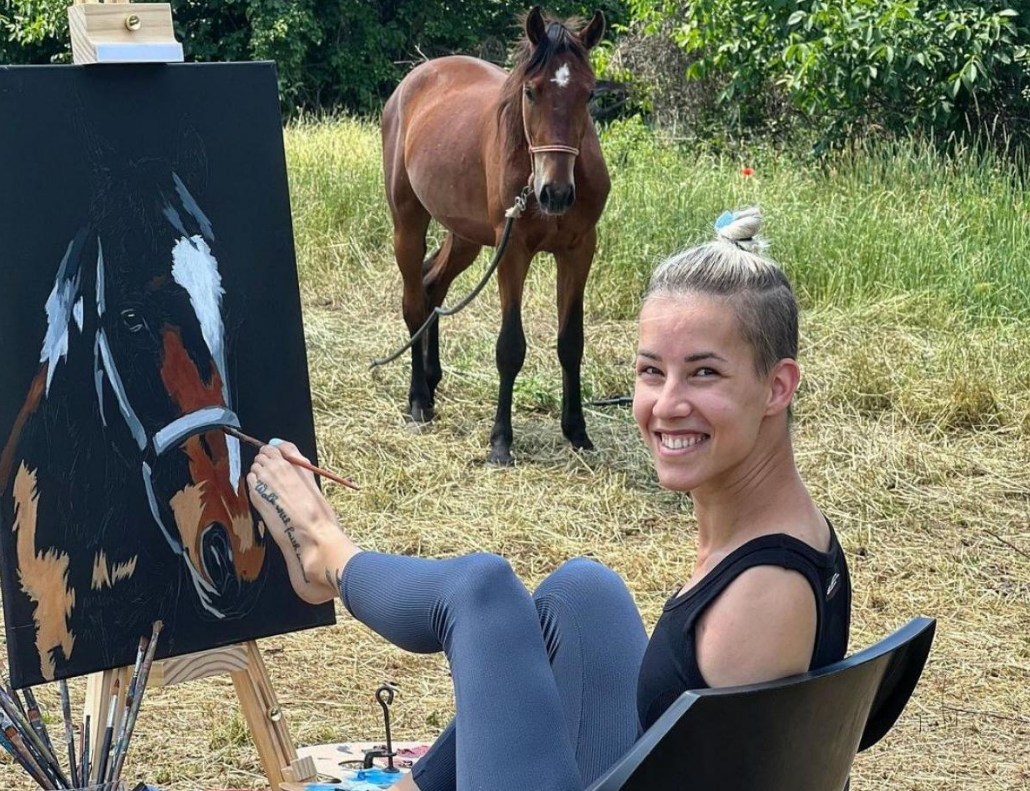 두 팔이 없는 여성이 발로 그림그리는 장면