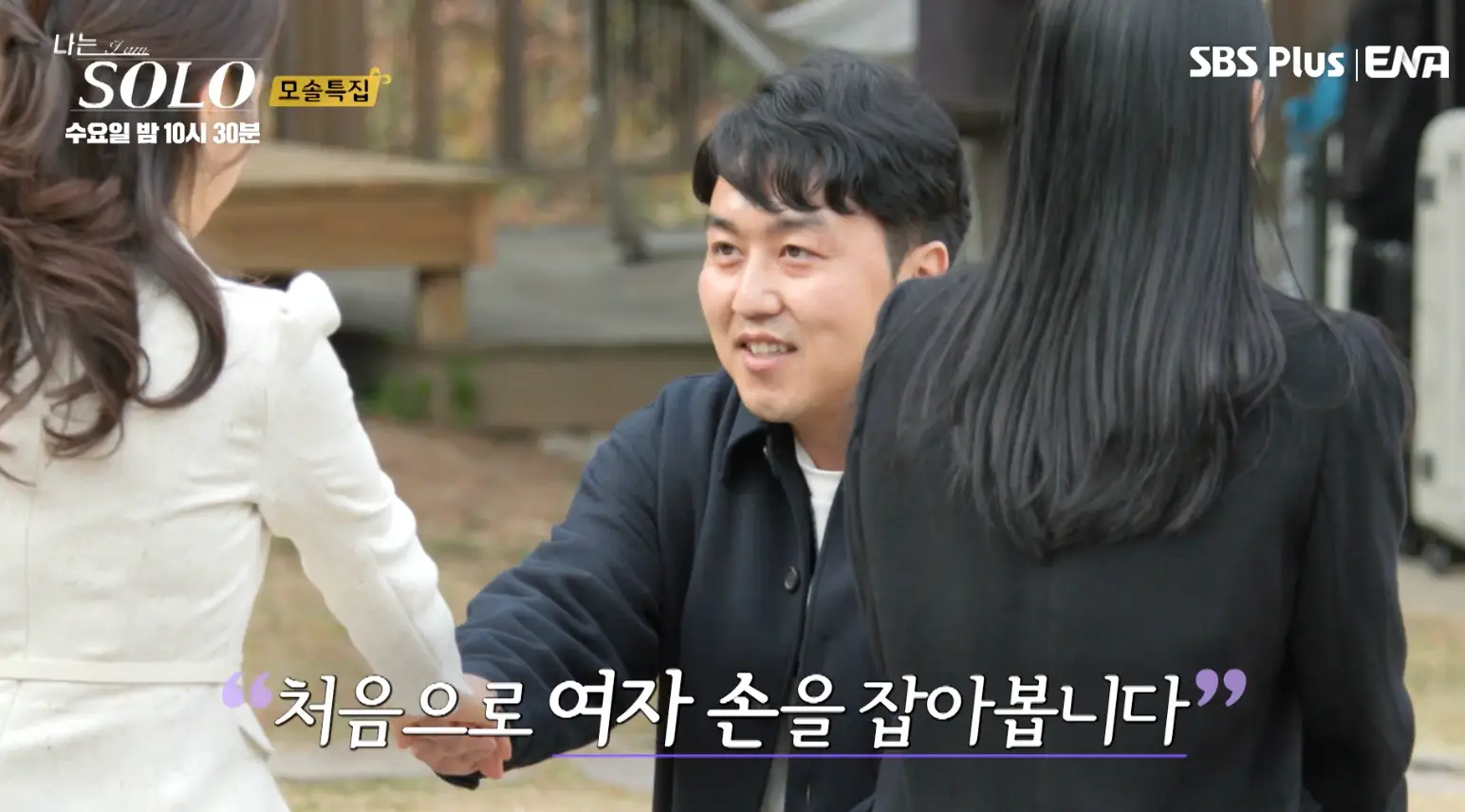 솔로- 파란 점퍼 흰색 니트를 입고 흰색옷을 입은 여자에게 손을 내밀고 있는 영식