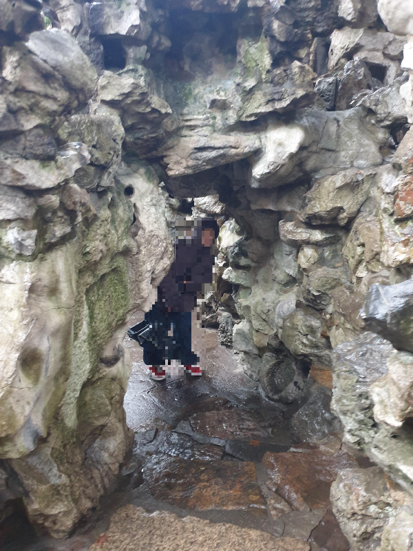 바위 틈 사이로 난 길로 사진을 찍는 모습