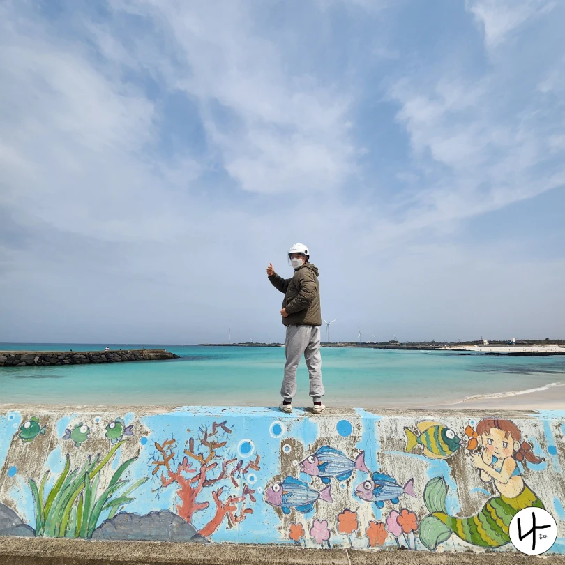 해안가-돌담-위-서있는-남자