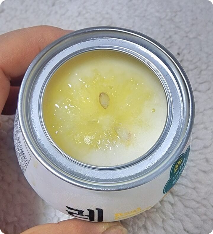 노란색 얼음이 든 캔을 들고 있는 손