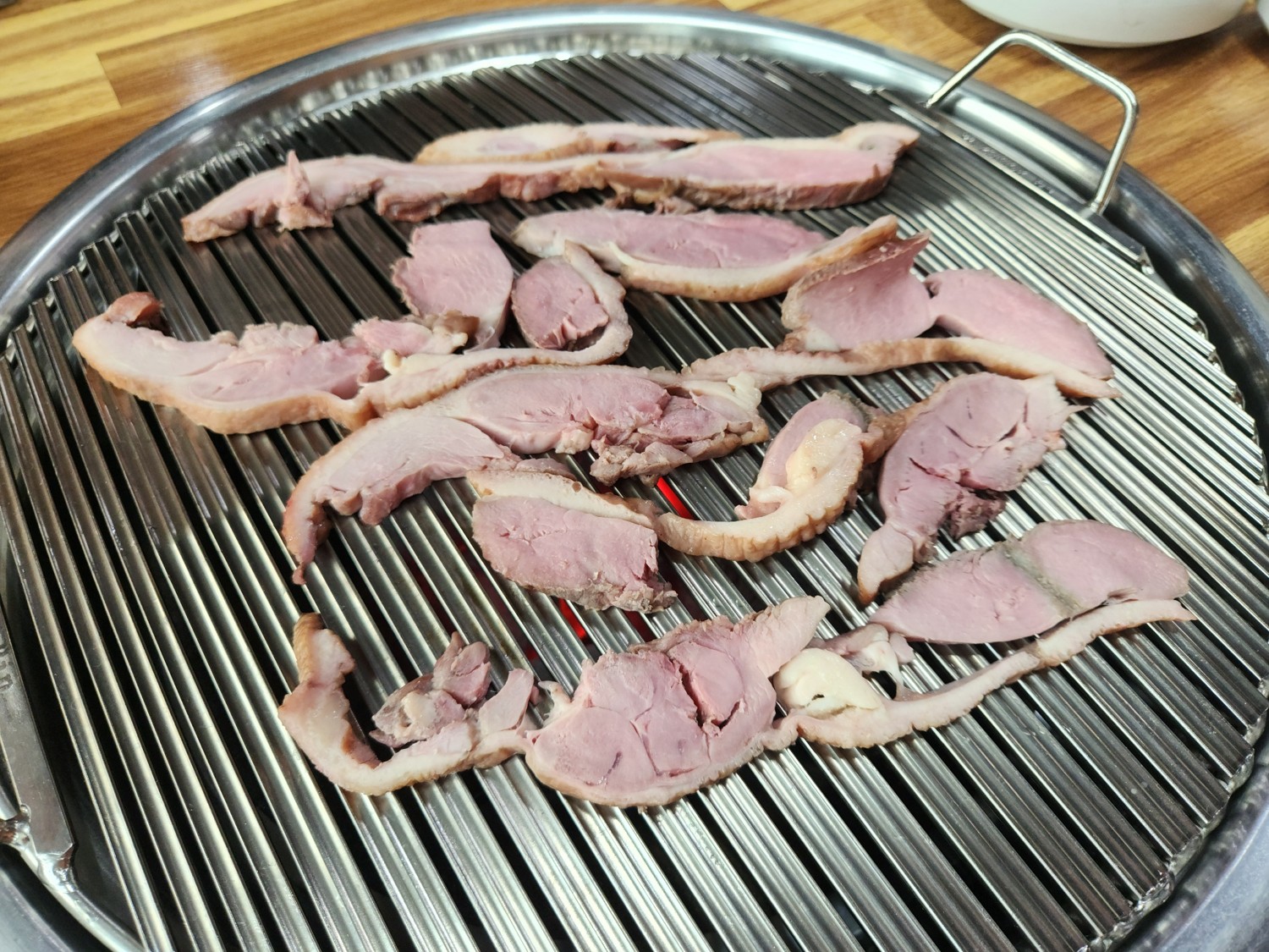 불판 위에 오리고기를 올려놓고 조리하고 있다