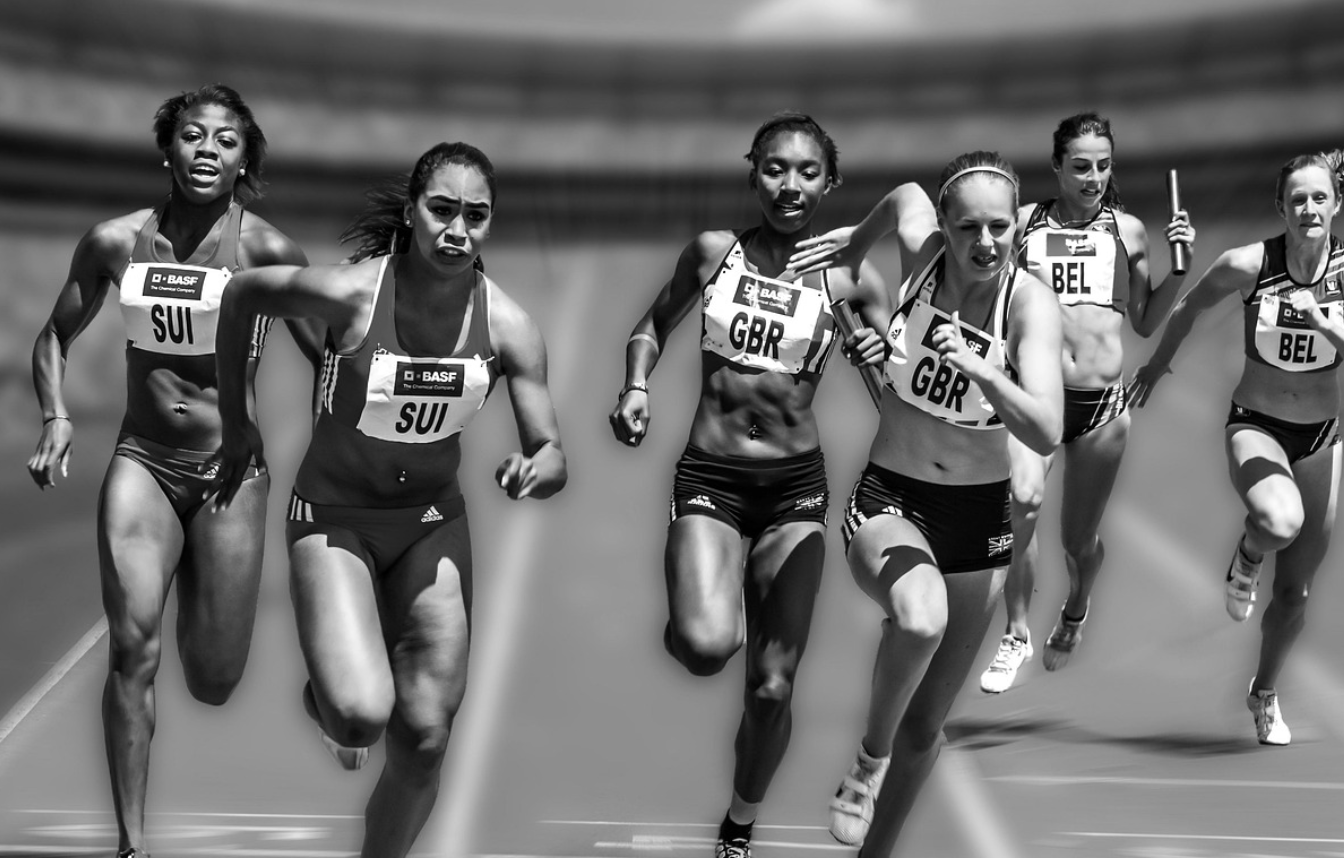 여자 달리기 선수들이 트랙을 달리고 있다