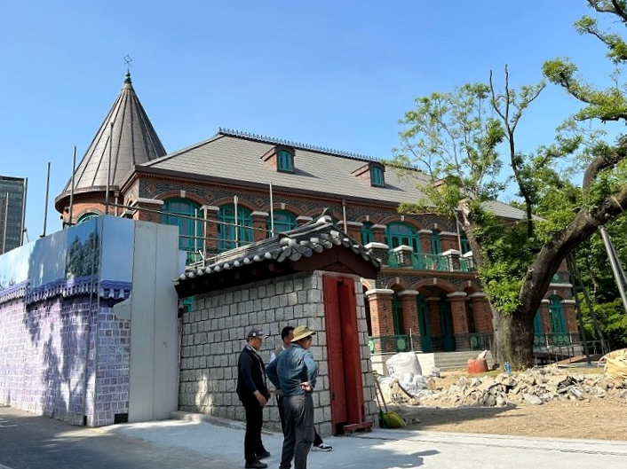 벽돌-건물-공사-현장-앞에-있는-사람들의-모습을-찍은-사진