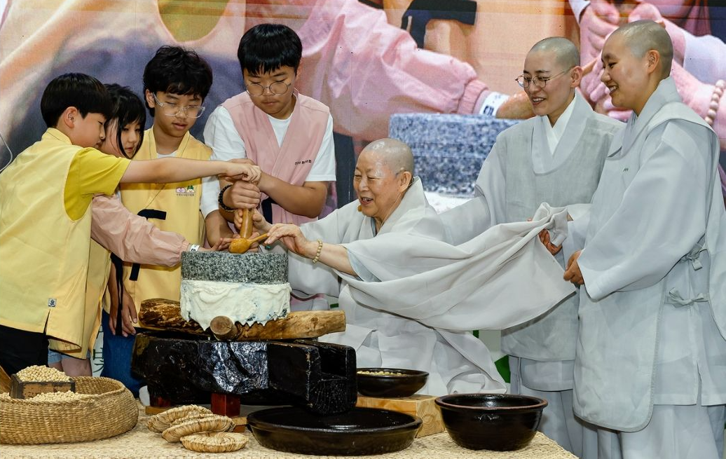 제4회 사찰음식 대축제에서 스님과 아이들이 전통 맷돌 체험을 하는 모습