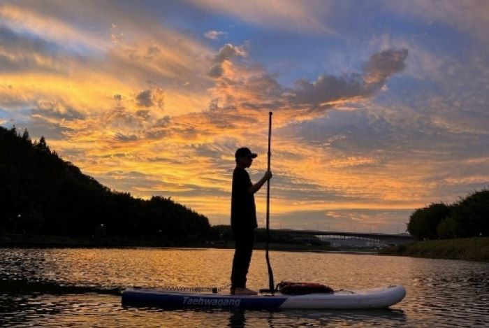 태화강 노을을 배경으로 패들보드 타는 모습