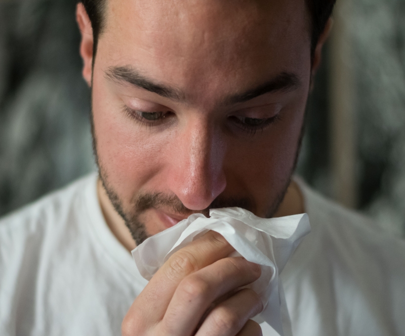 휴지로 코를 훔치고 있는 남자