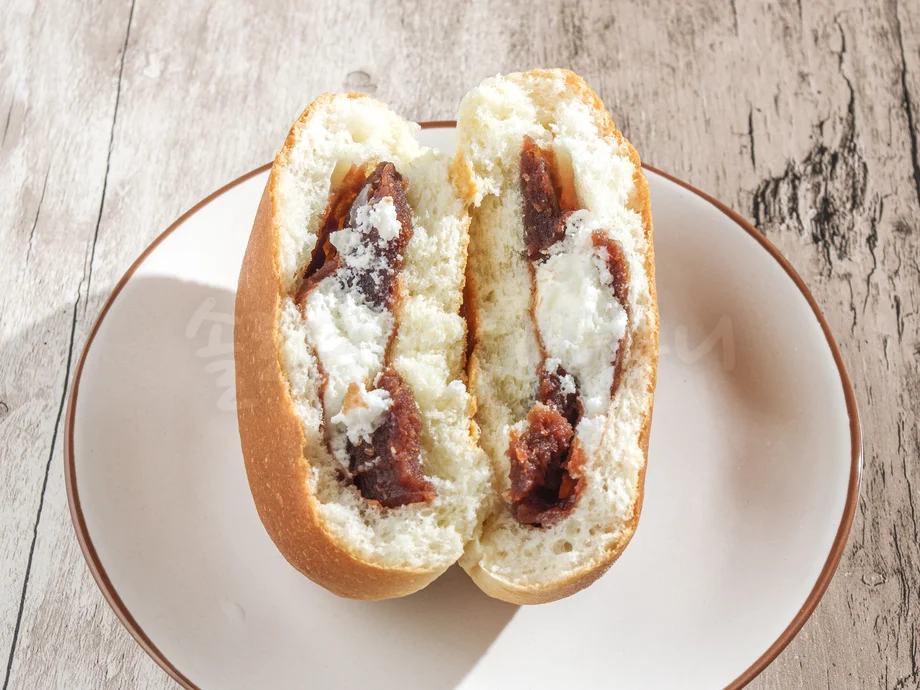 반으로 나뉘어 빵 안의 단팥과 크림이 보이고 있다