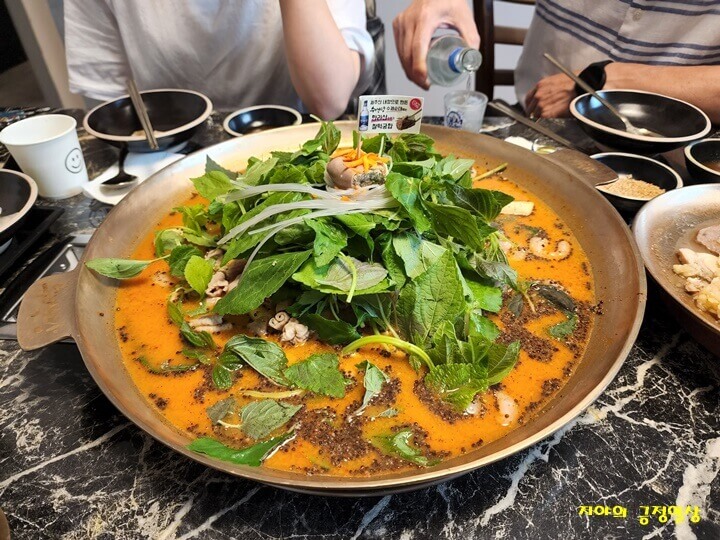 방짜유기에 담겨져 온 육수, 순대, 새우, 곱창이 든 전골