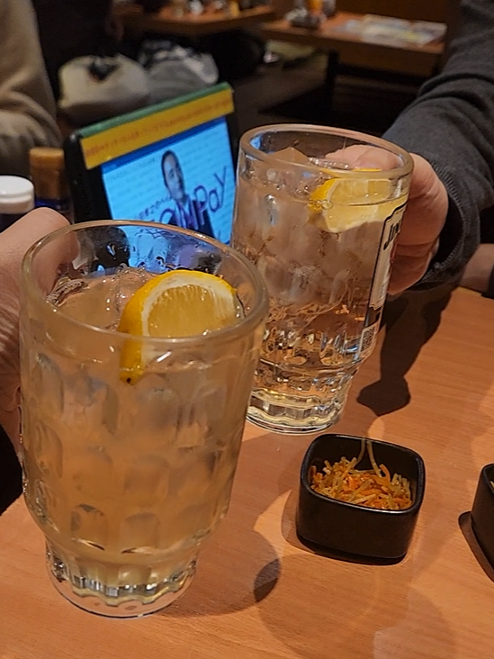 하이볼로 건배로 하고 있는 부부. 책상 위에는 주문용 태블릿도 보인다.