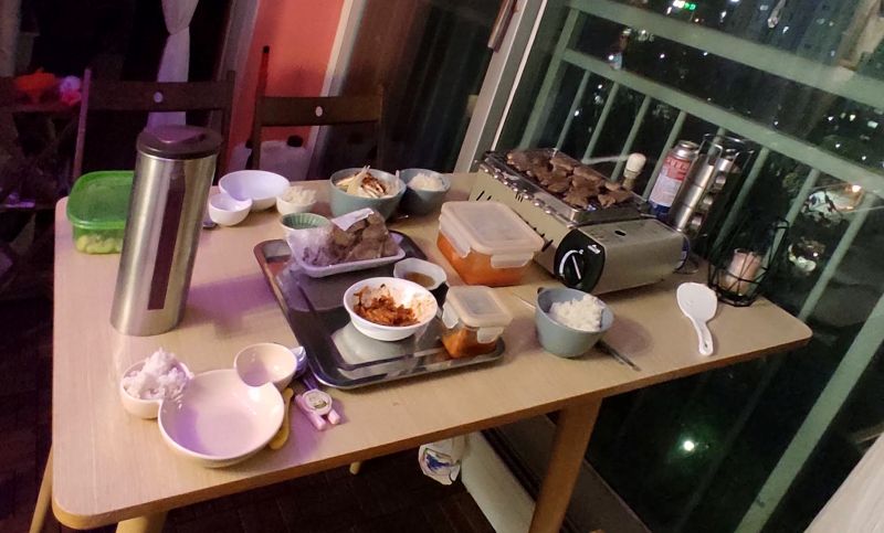 베란다 창문을 열고 테이블을 펼쳐 고기구워먹는중