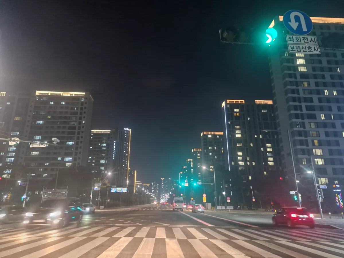 깜깜한-밤하늘-횡단보도-사이로-불빛이-켜져있는-아파트