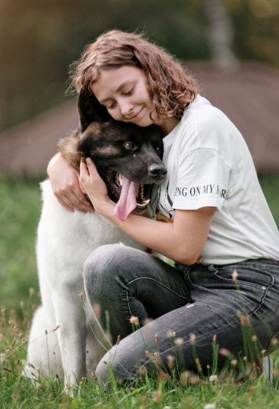 풀밭에서 주인에게 안겨 보호 본능을 발휘하며 신뢰를 표현하는 강아지