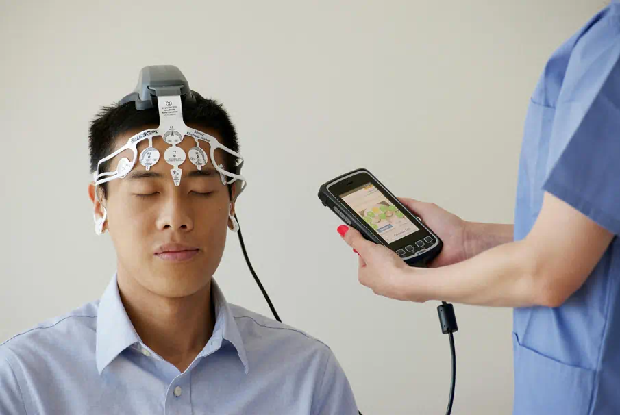 한 남성이 눈을감고 뇌 검사를 받고있다