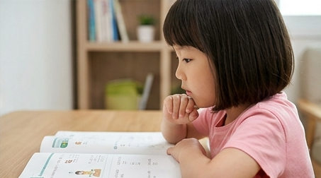 문제집 앞에서 골똘히 고민하는 아이의 옆모습