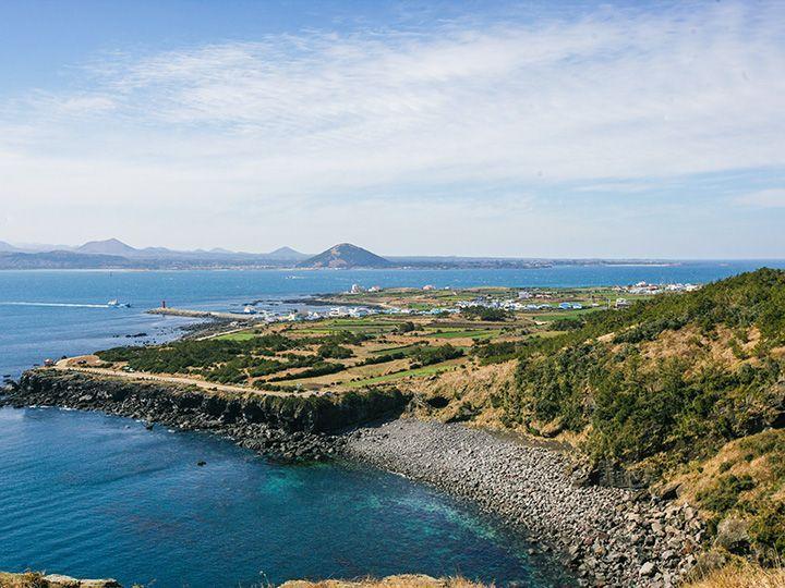 성산일출봉과 광치기해변이 함께 보이는 제주 동부 파노라마 풍경 (AI 제공)