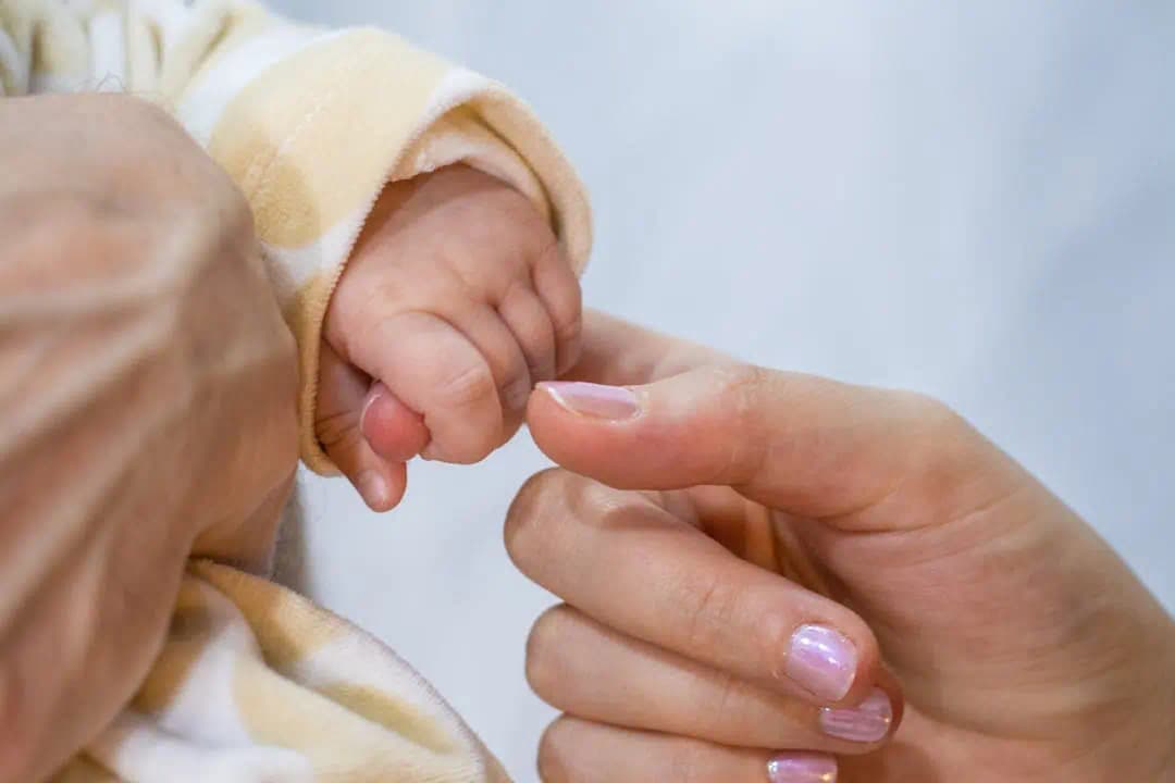 신생아의 손을 잡고 있는 엄마의 모습, 부모급여 신청의 첫걸음