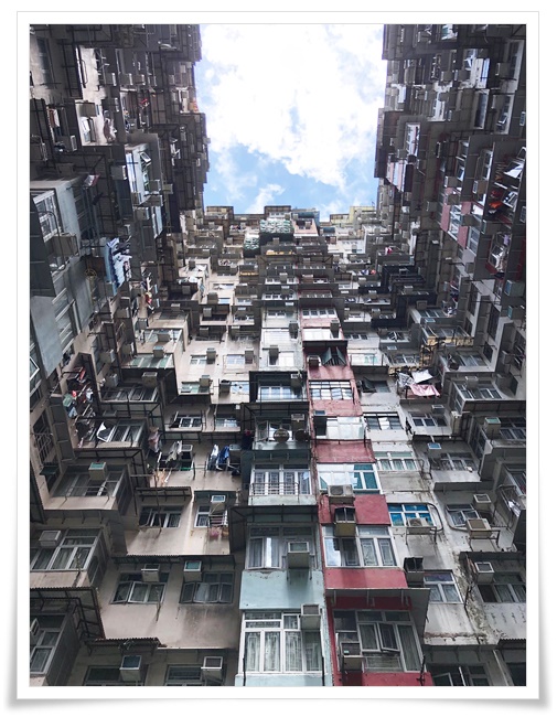'ㄷ' 형태의 고층 건축물을 밑에서 위로 바라보는 사진 .
건물의 중앙으로 공터가 있고 벌집처럼 각 가구의 베란다 창문들이 빼곡히 설치되어있다