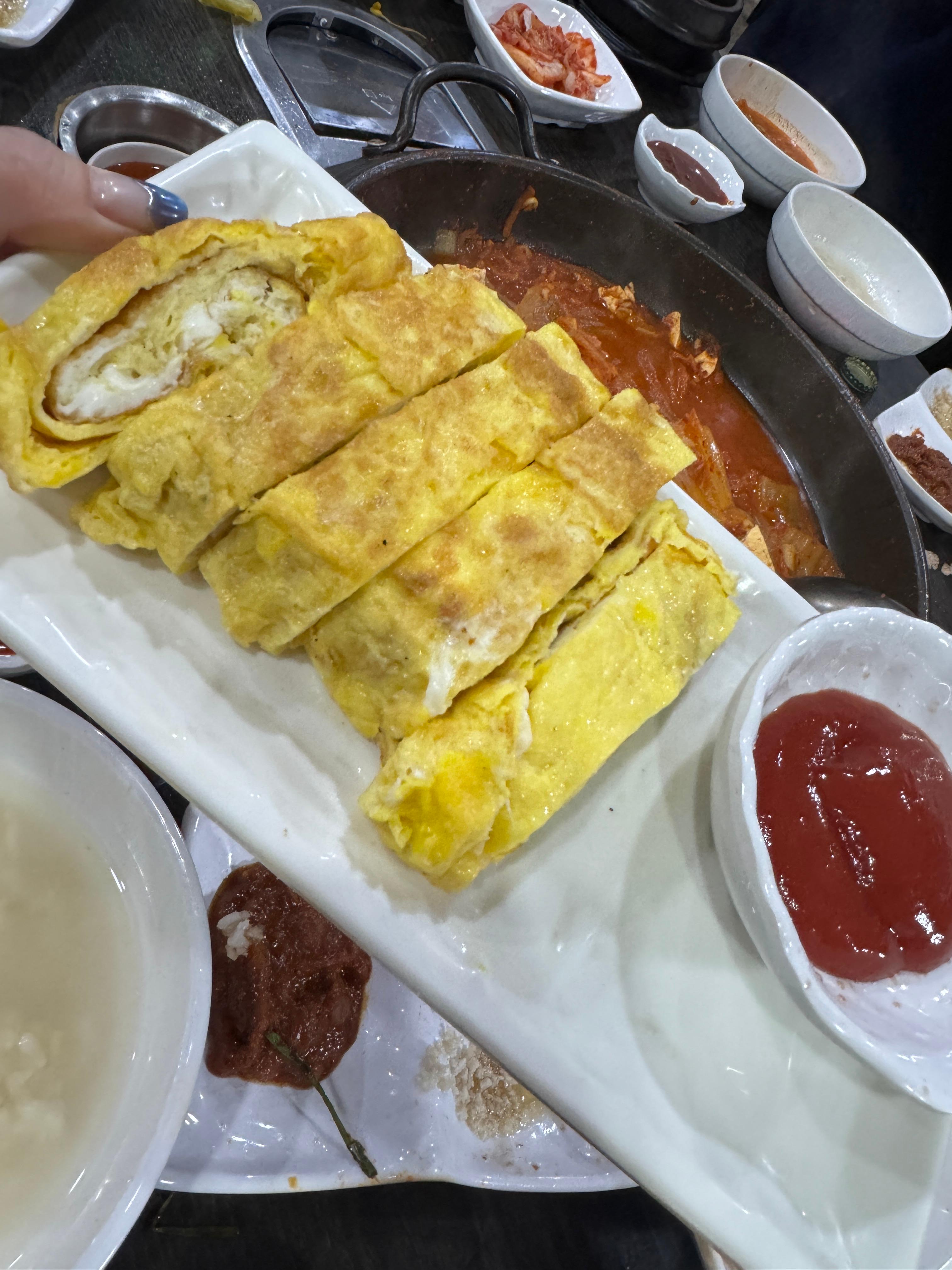 폭신하게 부쳐진 계란말이가 접시에 담겨 있고&amp;#44; 옆에 케첩이 함께 나와 있다. 