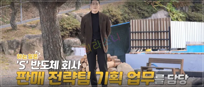 상철이 나무 옆에서 차분한 표정으로 서 있는 모습이다. 두 손을 주머니에 넣고 있으며&amp;#44; 배경에는 장작이 쌓여 있고 벤치가 보인다. 자막: 