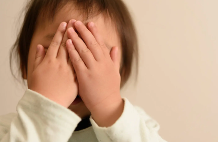 손으로 얼굴을 가린 아이