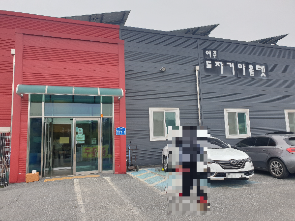 회색 판넬로 지어진 건물 출입구만 붉은색이다.