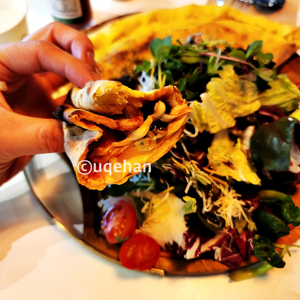 페퍼로니깔조네를 손으로 들고 있다.